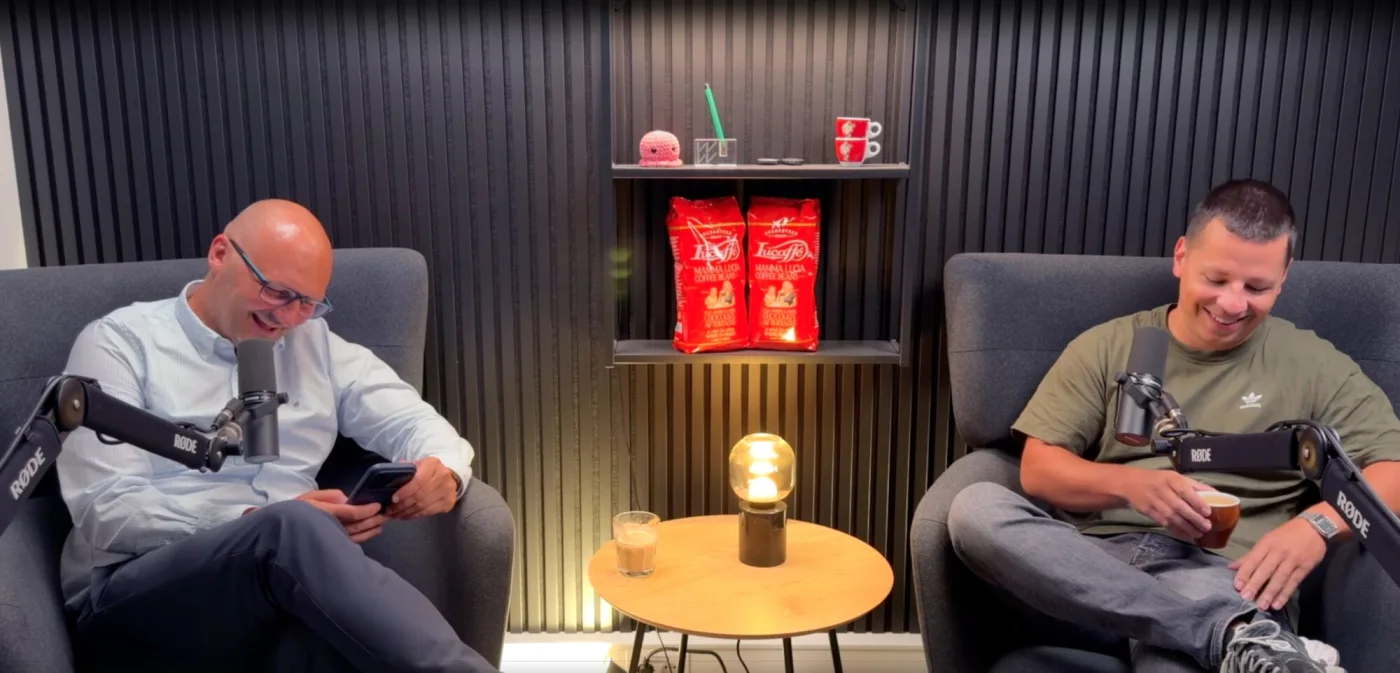 Marco Morinello und Manuel Frambach nehmen KI-Snack im Kölner Podcast-Studio auf — an der schwarzen Akustik-Wand mit Rode-Mikrofonen
